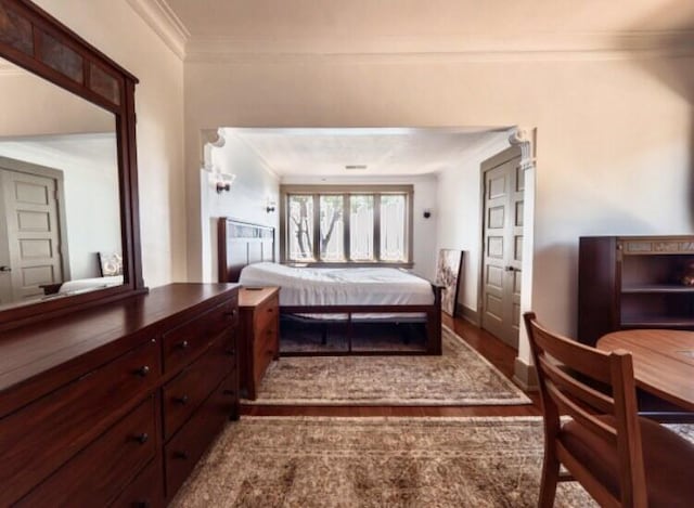 bedroom featuring wood-type flooring and ornamental molding