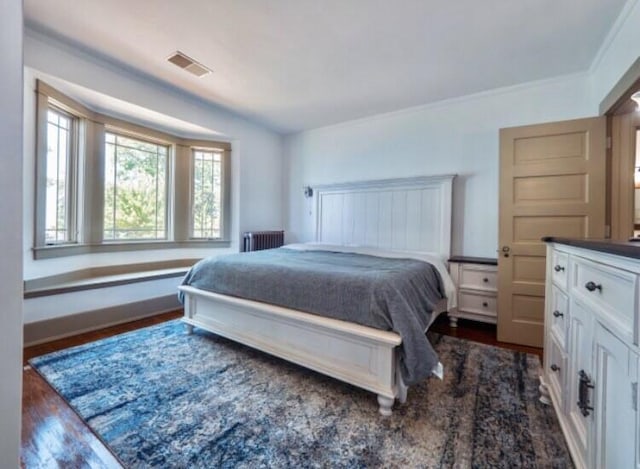 bedroom with radiator, crown molding, and dark hardwood / wood-style floors