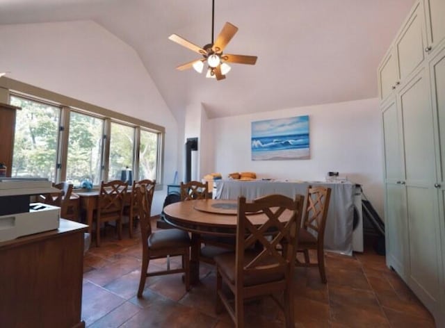 tiled dining room with ceiling fan and high vaulted ceiling