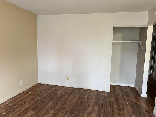 unfurnished bedroom featuring dark wood-type flooring and a closet