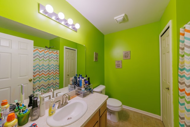 bathroom with tile patterned flooring, vanity, and toilet