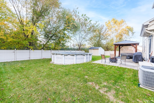 view of yard with a gazebo, a covered pool, and central air condition unit