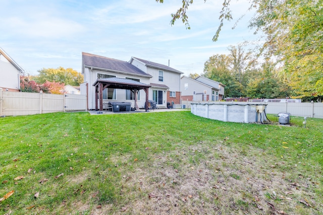 back of house featuring a gazebo, a lawn, central AC unit, and a fenced in pool