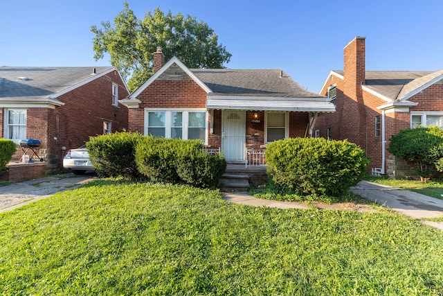 bungalow-style home with a front yard