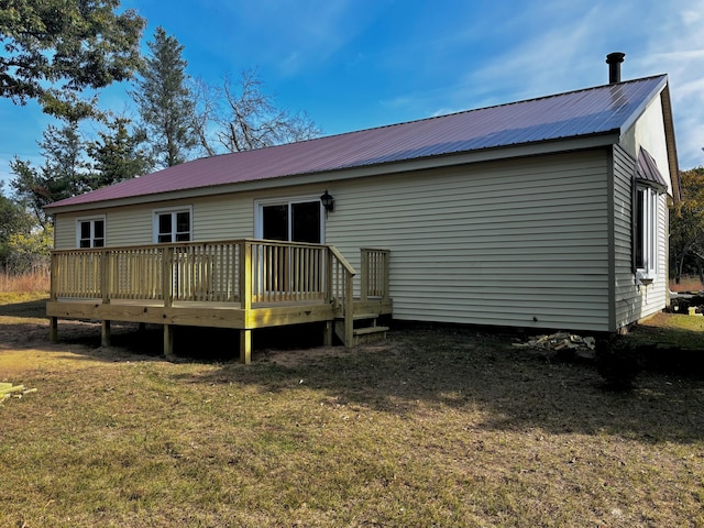 back of property with a yard and a wooden deck