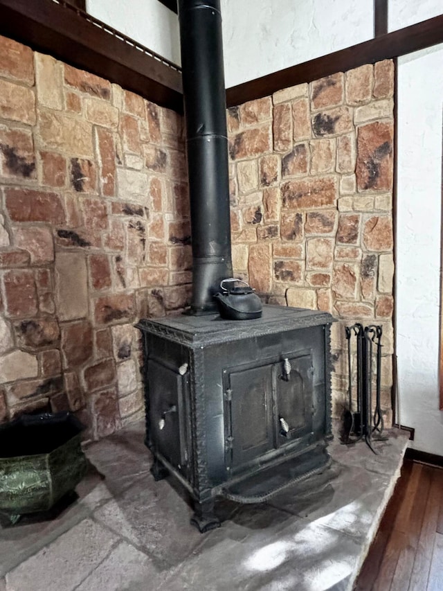 room details with hardwood / wood-style flooring and a wood stove