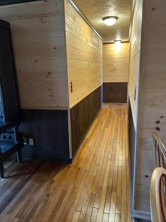 hallway featuring hardwood / wood-style floors and wood walls