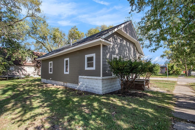 view of side of property featuring a lawn, cooling unit, and a trampoline