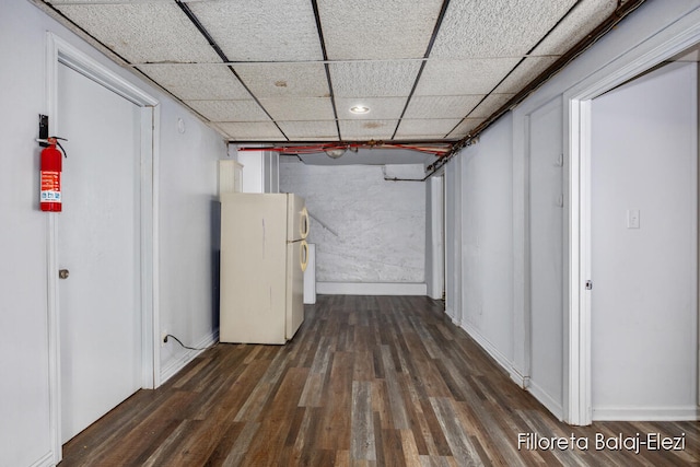 corridor with a paneled ceiling and dark hardwood / wood-style flooring