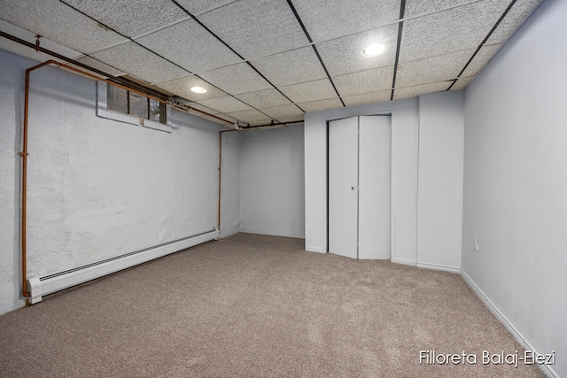 basement featuring carpet floors, a drop ceiling, and baseboard heating