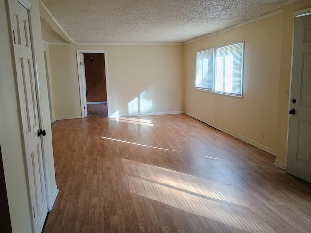 unfurnished room featuring a textured ceiling and light hardwood / wood-style flooring