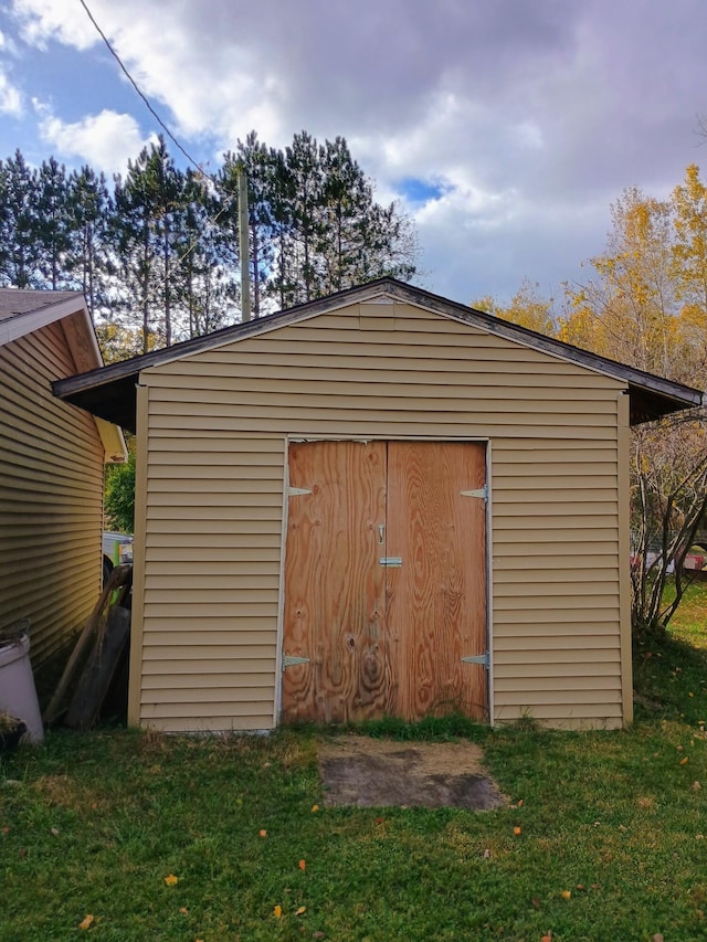 view of outbuilding featuring a lawn