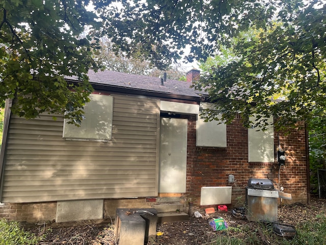8900 Artesian St, Detroit, MI 48228 - back of house with a chimney, brick siding, and entry steps