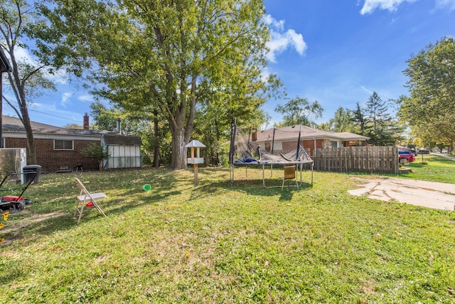 view of yard with a storage shed and a trampoline