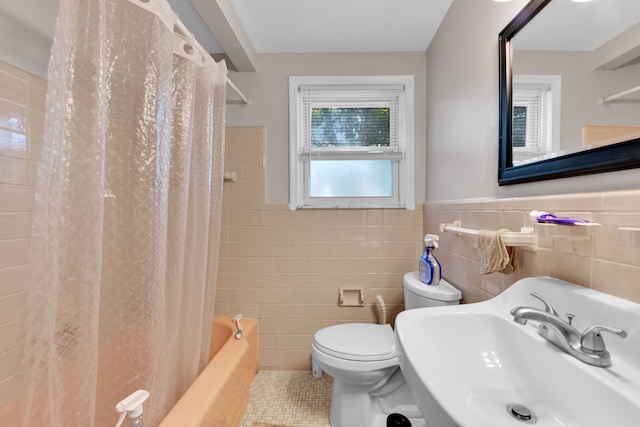 full bathroom with tile patterned floors, sink, shower / tub combo, and tile walls