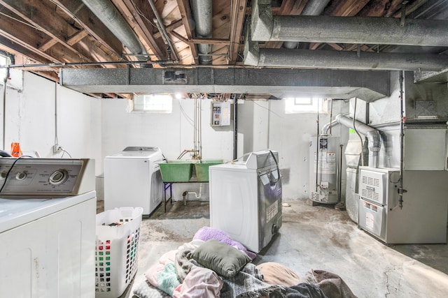 basement with plenty of natural light, washing machine and clothes dryer, electric panel, and water heater