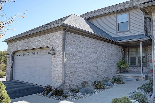 view of side of home with a garage and covered porch