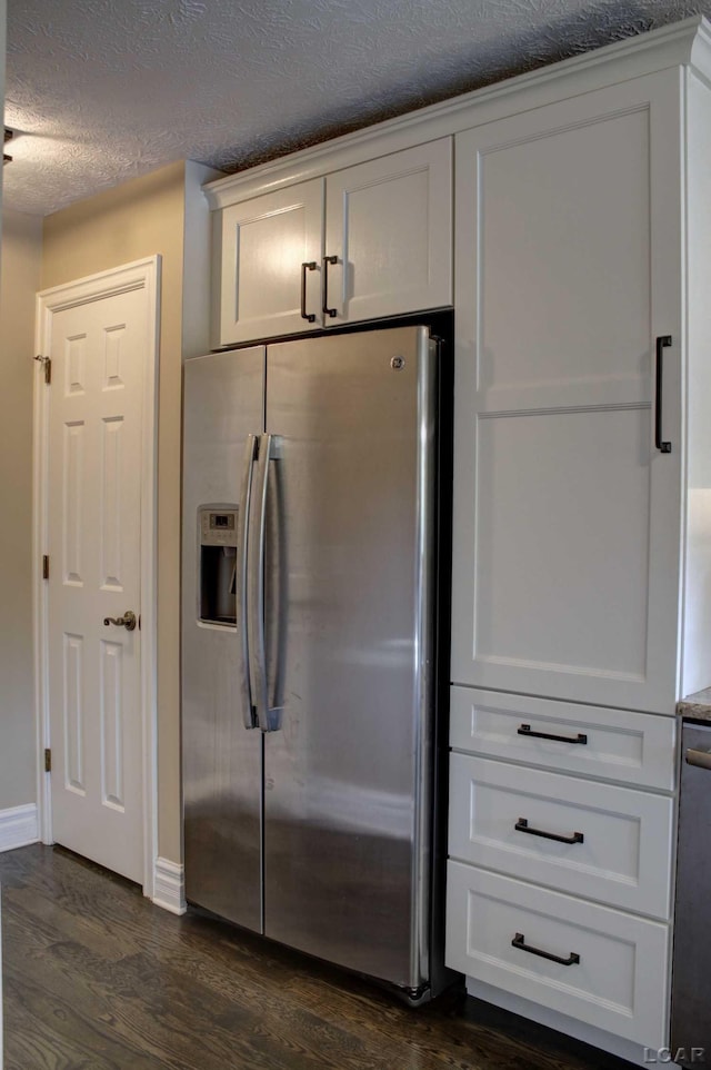 kitchen with stainless steel refrigerator with ice dispenser, dark wood-type flooring, a textured ceiling, and white cabinets