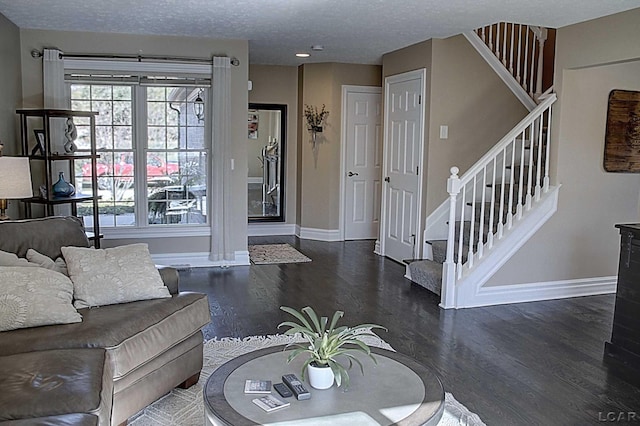 living room with dark hardwood / wood-style flooring and a textured ceiling