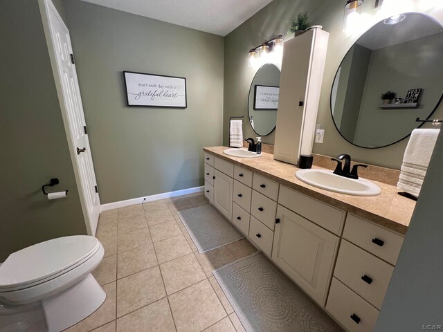 bathroom with vanity, tile patterned floors, and toilet