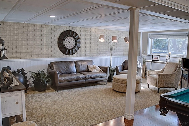 living room with hardwood / wood-style flooring, pool table, and decorative columns