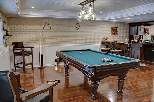 playroom with brick wall, hardwood / wood-style floors, bar, pool table, and crown molding