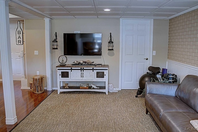 living room with ornate columns and hardwood / wood-style flooring