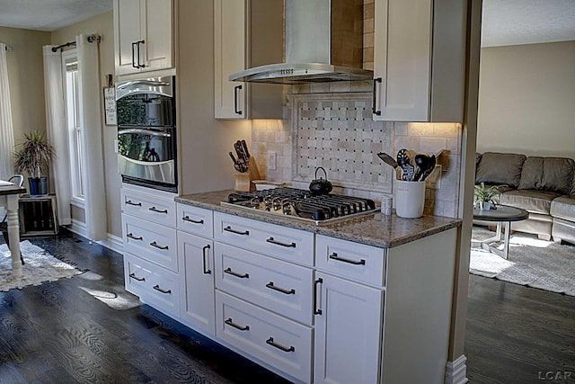 kitchen with light stone counters, exhaust hood, and white cabinets