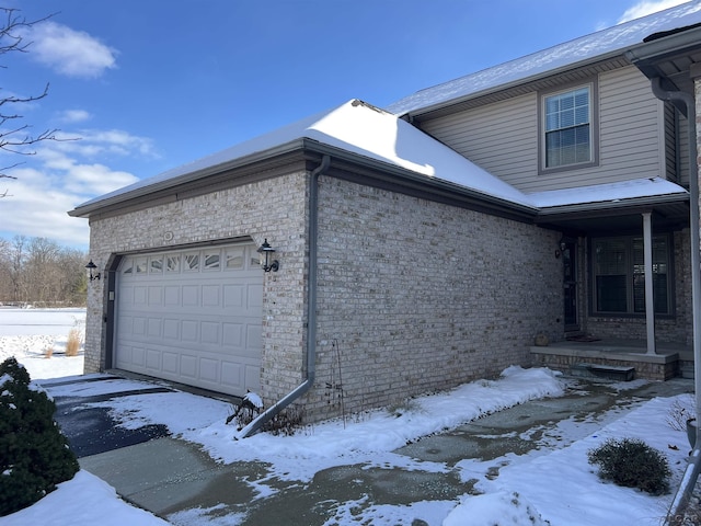 view of snow covered exterior featuring a garage