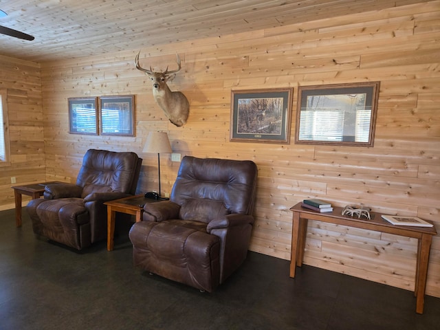 living area with wood ceiling, wooden walls, ceiling fan, and a healthy amount of sunlight