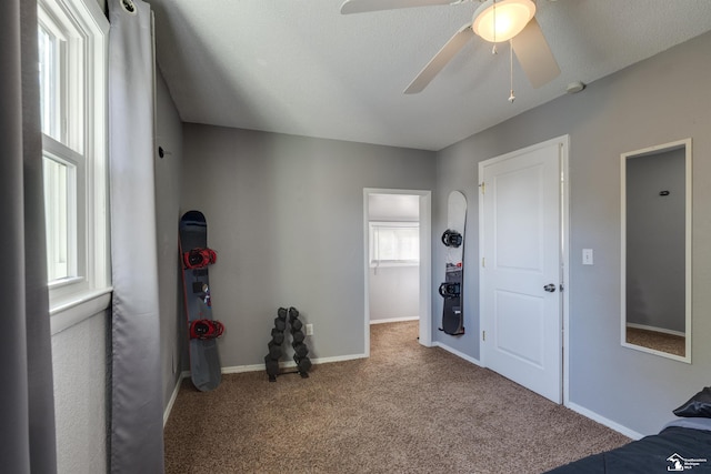 bedroom featuring carpet, ceiling fan, a textured ceiling, and multiple windows