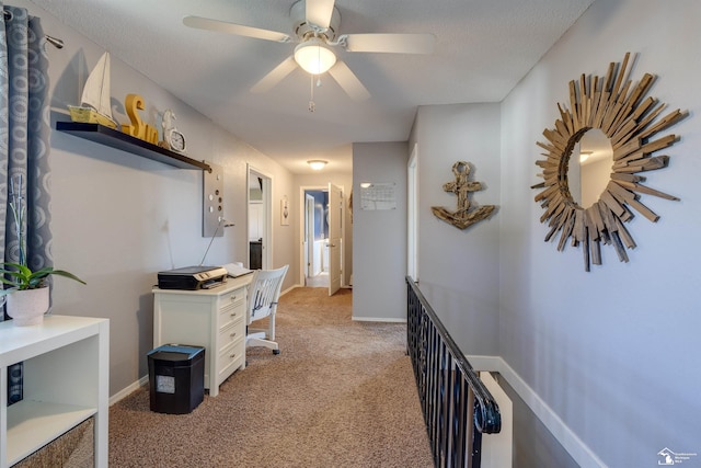 hall with an upstairs landing, baseboards, and light carpet