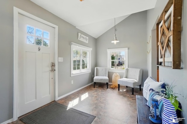 foyer entrance featuring baseboards and vaulted ceiling