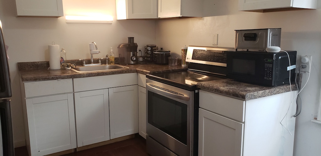 kitchen with sink, white cabinets, and appliances with stainless steel finishes