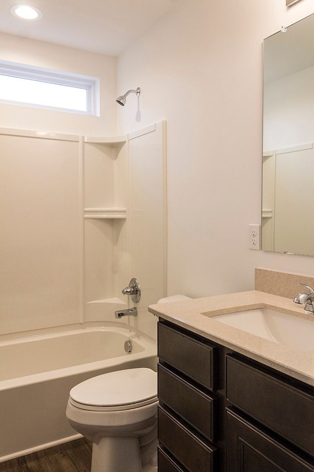 full bathroom with bathtub / shower combination, vanity, hardwood / wood-style flooring, and toilet