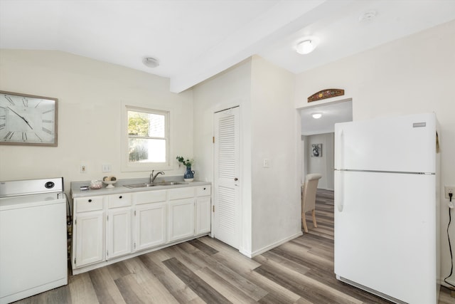 kitchen with white cabinetry, sink, white refrigerator, washer / clothes dryer, and light wood-type flooring