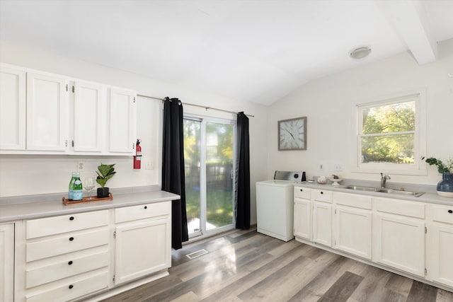 laundry area featuring washer / clothes dryer, sink, and light wood-type flooring