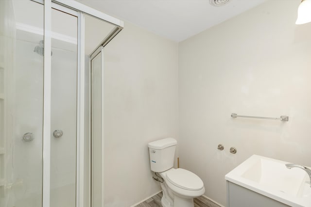 bathroom with toilet, a shower with door, and hardwood / wood-style flooring