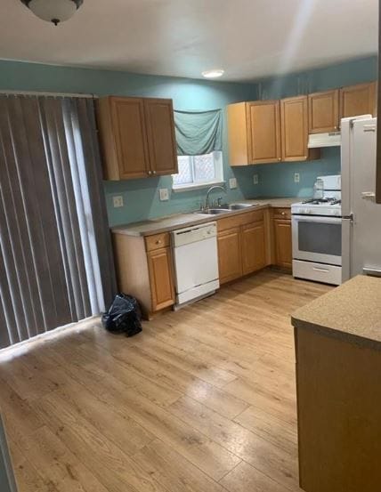 kitchen with white appliances, light hardwood / wood-style floors, and sink