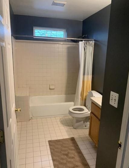 full bathroom featuring tile patterned flooring, vanity, toilet, and shower / bath combo with shower curtain