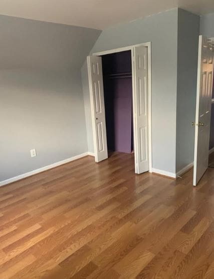 unfurnished bedroom with a closet and hardwood / wood-style flooring