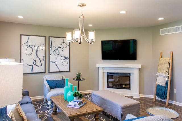 living room with dark hardwood / wood-style floors and a chandelier