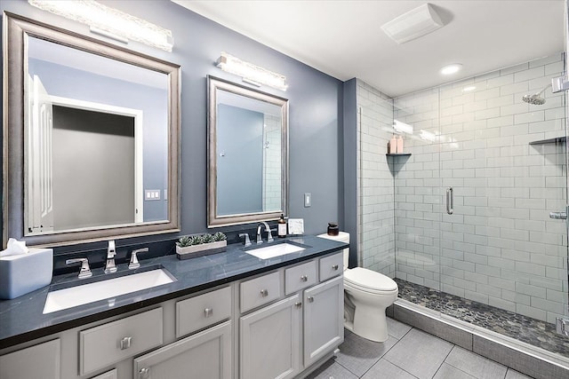 full bathroom featuring a sink, toilet, a stall shower, and double vanity