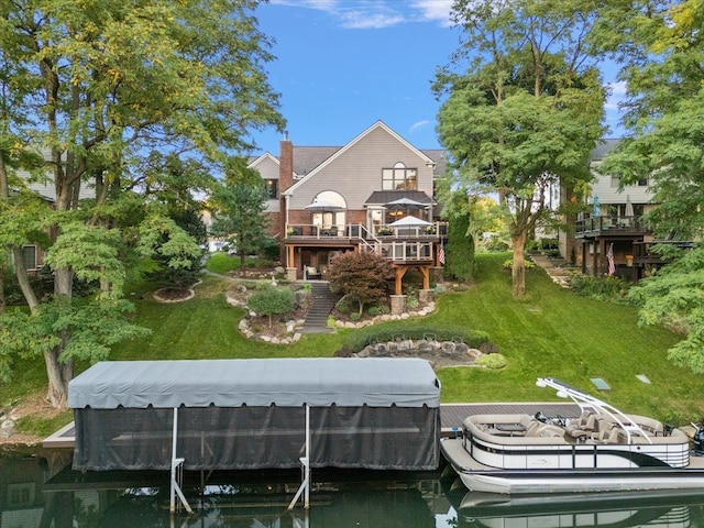 rear view of property with a yard and a deck with water view