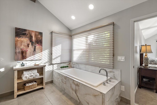 bathroom with tile patterned flooring, vaulted ceiling, a garden tub, and recessed lighting