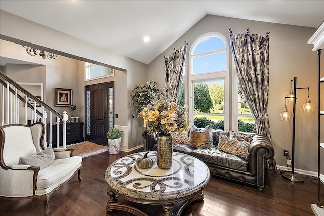 living area with stairway, high vaulted ceiling, baseboards, and hardwood / wood-style floors