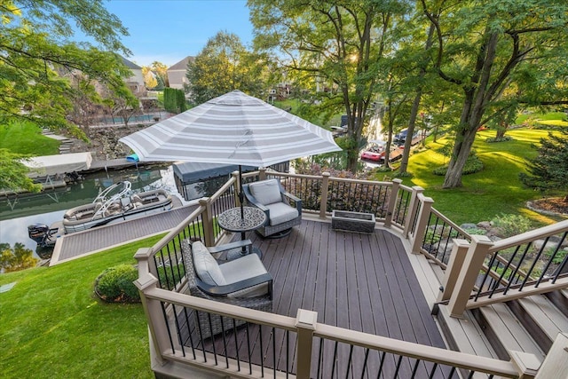 deck with a yard and a water view