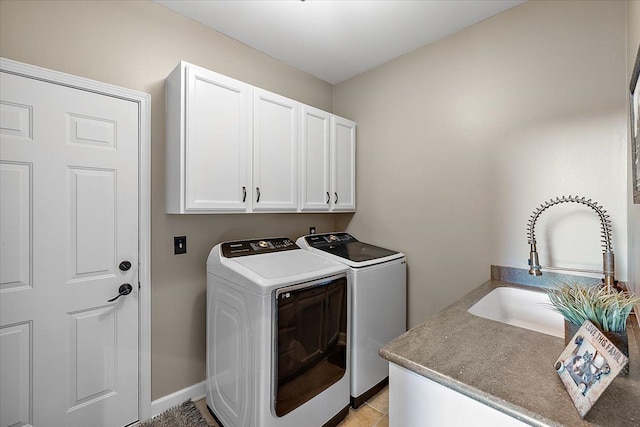 laundry room with light tile patterned flooring, cabinets, separate washer and dryer, and sink