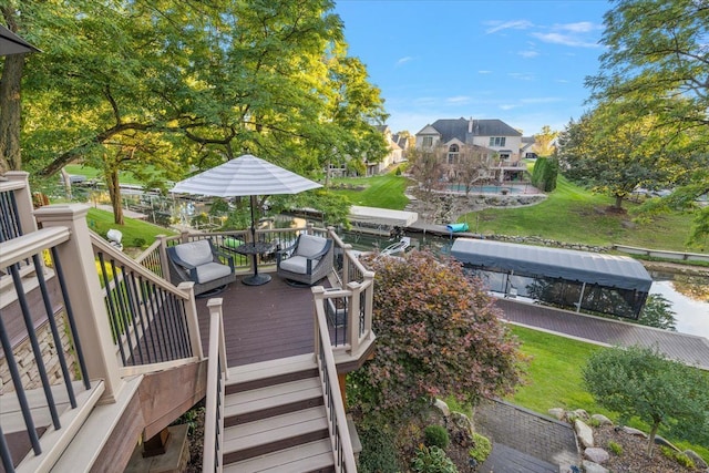 wooden terrace featuring outdoor dining area and a yard