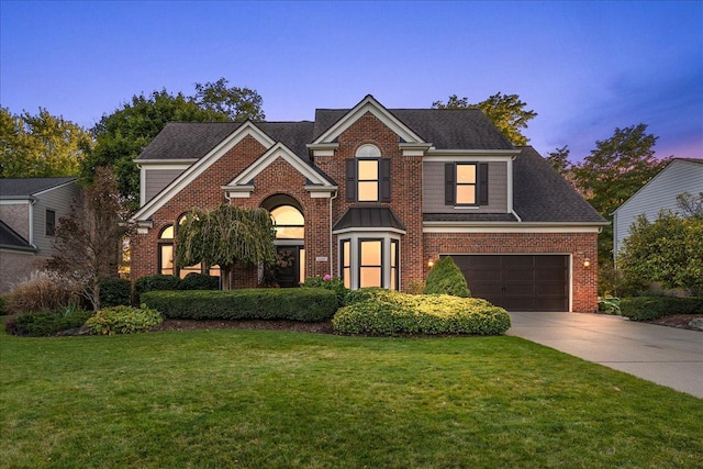 view of front facade with a garage and a lawn